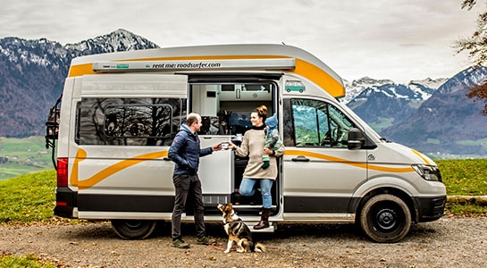 Enjoying coffee in a rented campervan with a view of Swiss mountains