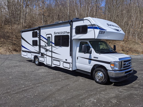 A family enjoying their rented Sunseeker Class C Motorhome in a forest campground