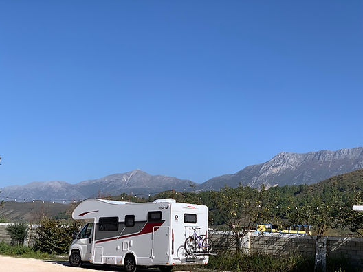 A rented motorhome parked near a classic Greek village