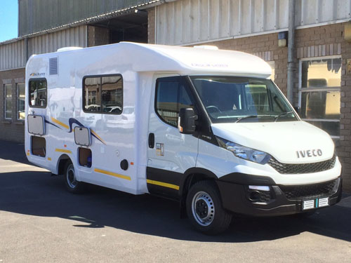 White Iveco Class C Motorhome parked with a scenic mountain backdrop