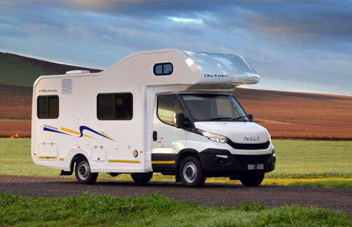 White Iveco Discovery Class C Motorhome - Exterior Side View on Country Road