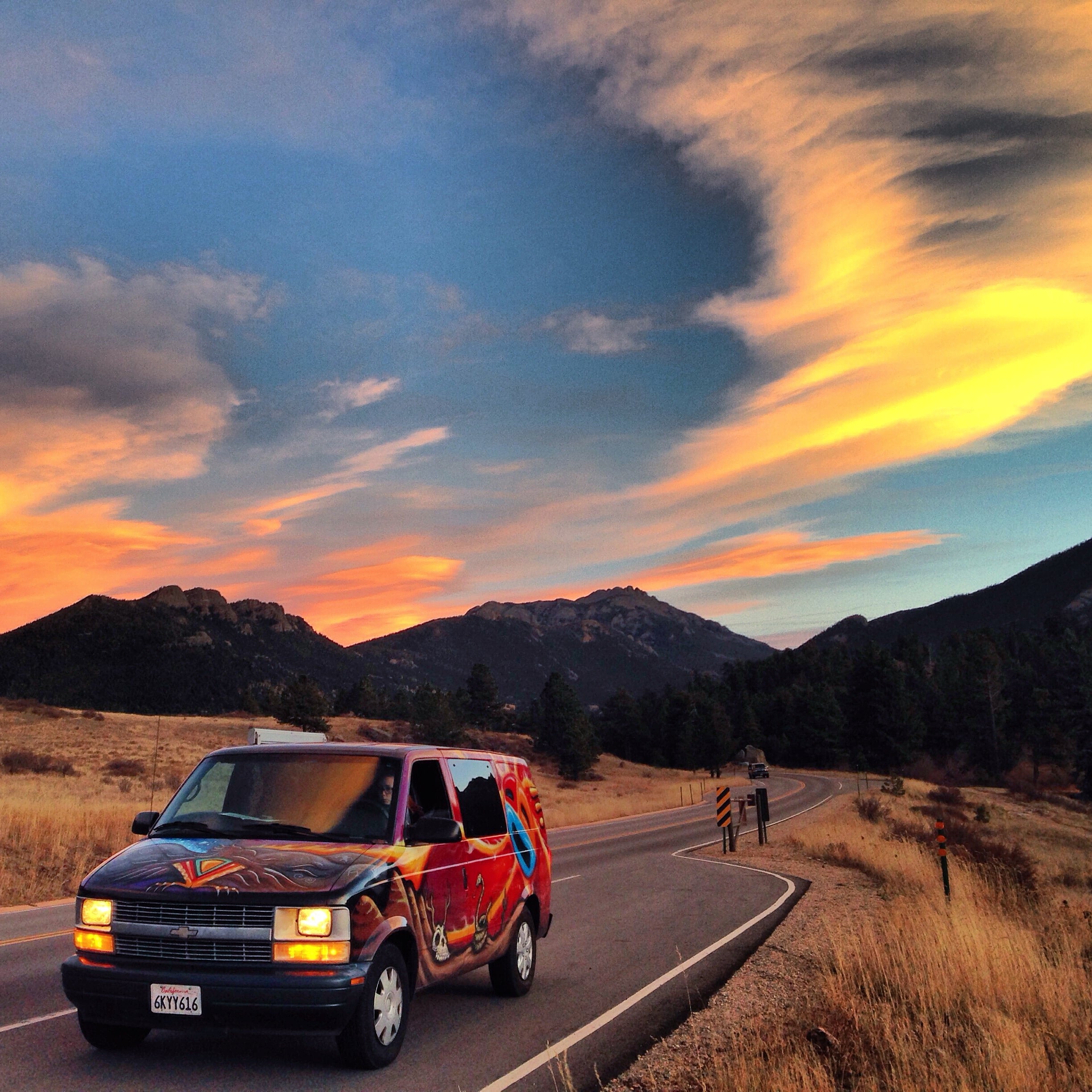 A campervan driving on a scenic road in the Rocky Mountains near Denver