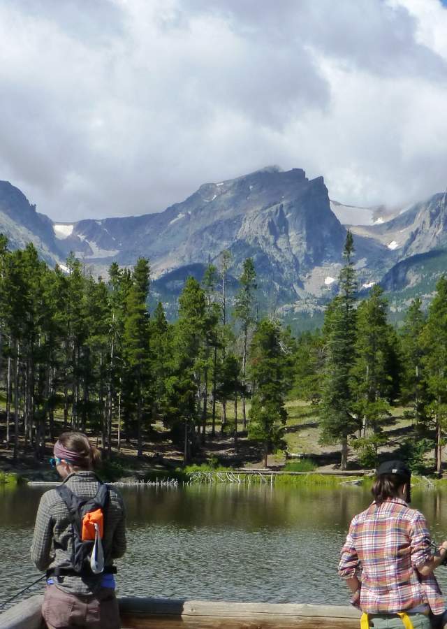 Fishing by a lake near Denver with mountains in the background