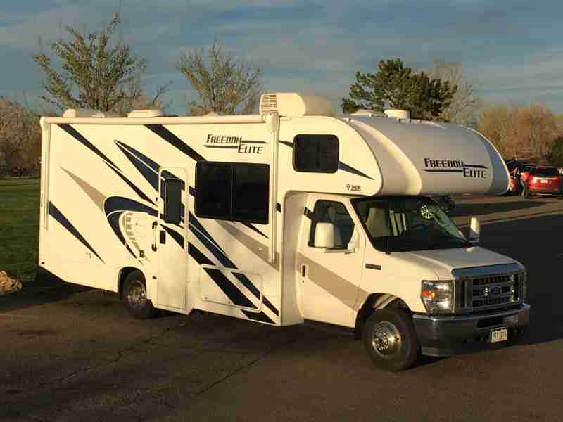 A Class C motorhome ready for an adventure, parked in a scenic Denver-area location