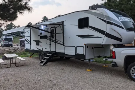 A family smiling in front of their rented Class C motorhome in Denver