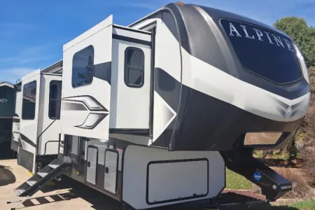 A family smiling in front of their rented Class C motorhome near Denver