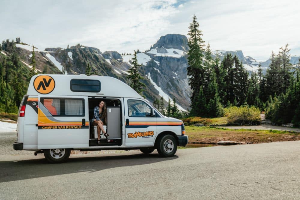 A campervan on a Los Angeles road trip with city lights in the background