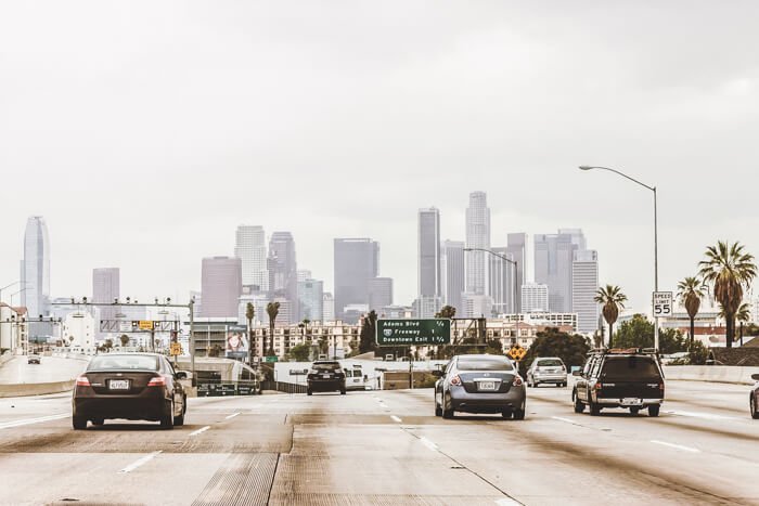 Driving on a freeway in Los Angeles with palm trees.