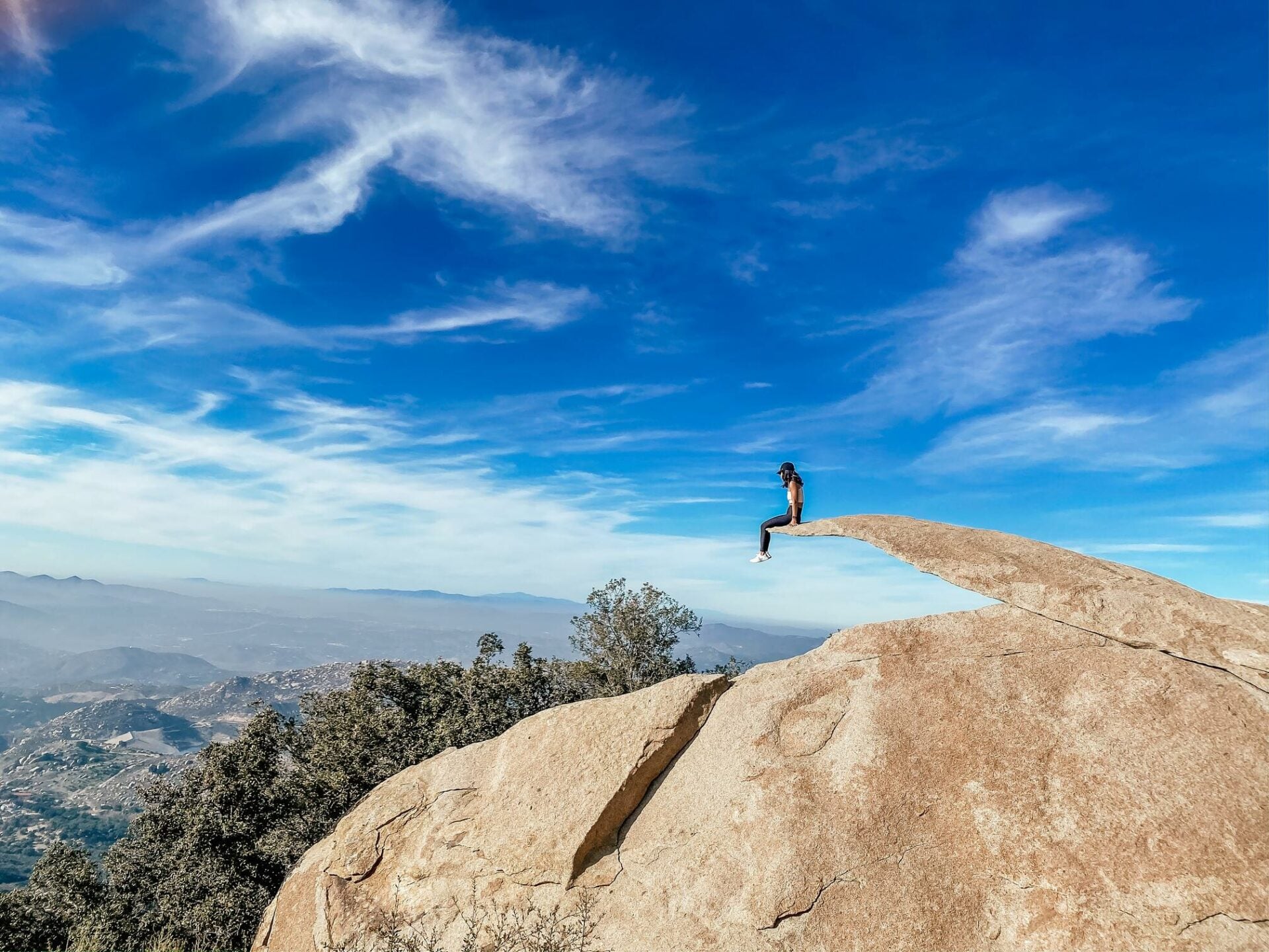 Hikers on the unique Potato Chip Rock formation in San Diego County.