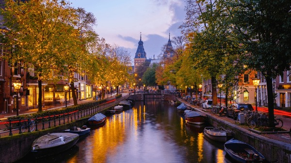 Amsterdam canals at twilight, reflecting the city lights and historic buildings