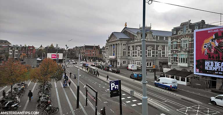 Driving through the streets of Amsterdam with trams and cyclists