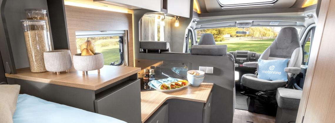 A compact campervan parked by a tranquil lake in the Dutch countryside near Amsterdam