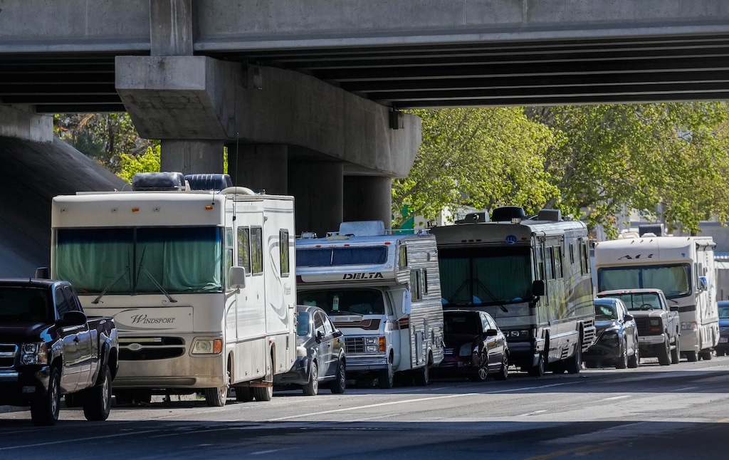 Different classes of RVs lined up with the Salt Lake City skyline in the background